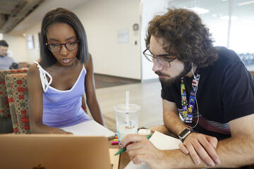 two students looking at a laptop