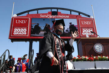 graduate waving on stage