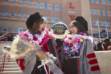 two graduates laughing 
