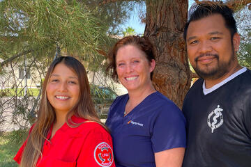 A woman stands next to her parents