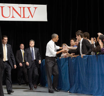 President Obama as he walks by and shakes the hand of excited young adults.