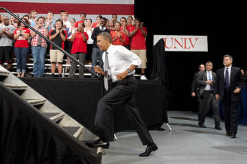Side view of President Obama as he walks up a set of stairs which lead to the stage.