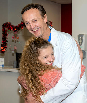 teenage patient hugging doctor in medical offices