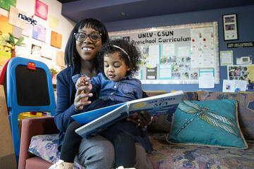 woman in preschool reading to daughter