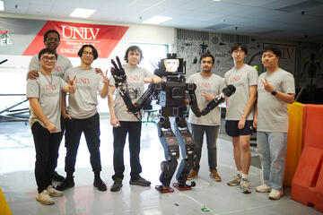 team of students pose with robot they built