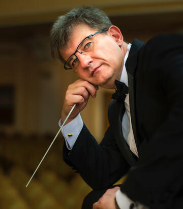 closeup photo of male conductor holding a baton