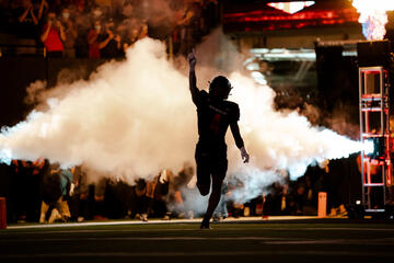 outline of football player with smoke behind him