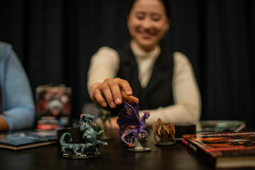 person playing with D&D-like figures