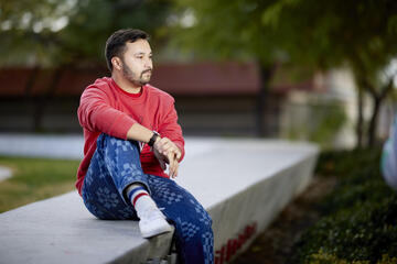 Ryder Hankins sits on a bench while filming an episode of The College Tour