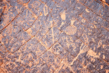 close up of carved drawings on reddish rockface