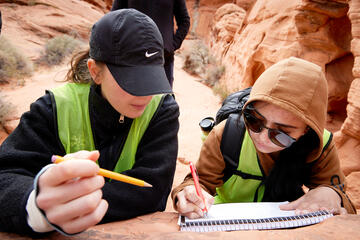 two female students working on a site map at archaeological site