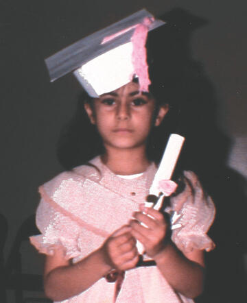 preschooler in pink dress and mortar board with pink tassel