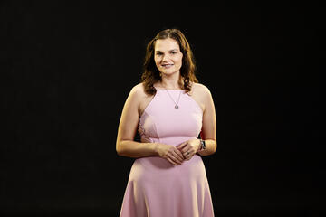 Woman in a pink dress in front of a black background