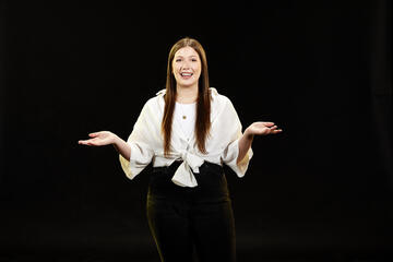 Woman in white shirt in front of black background