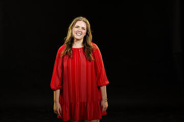 Woman in a red dress in front of a black background
