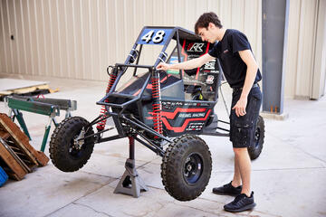 young male working on a racing vehicle