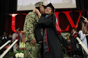 US Navy officer greets daughter on stage at commencement