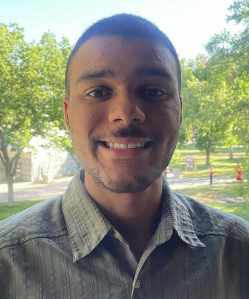 portrait photo of male student with trees in background