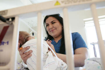 physical therapist working with infant in hospital setting