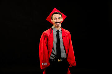Dhruv Luhar wears a red cap and gown to celebrate graduation