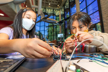 two students working on wires for engineering project