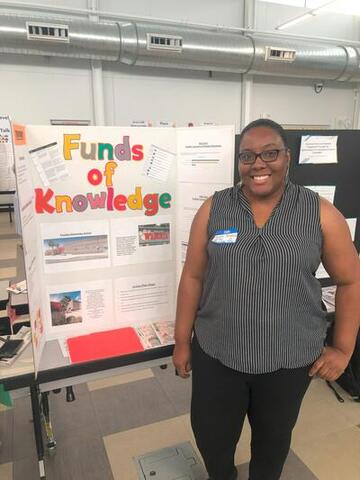 woman with glasses in front of board that reads "Funds of College"