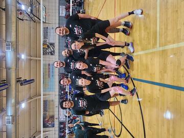 volleyball group posing on court for group photo