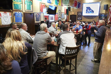 large group of people listening to a presentation at a pub