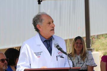 man in medical coat speaking at podium