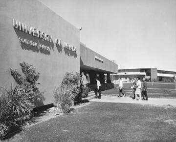 black and white photo of students walking into a building