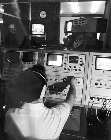 behind the head photo of man adjusting controls on production equipment