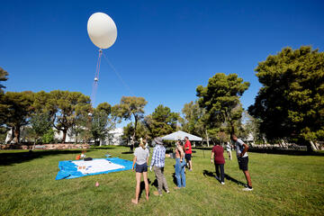 individuals outside watching a science balloon launch