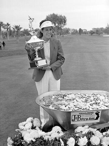 woman holding trophy on golf course
