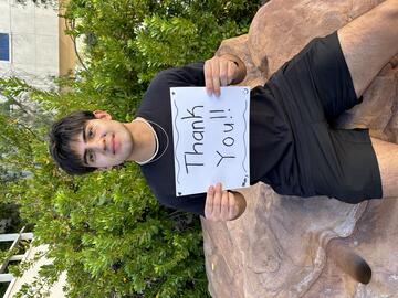 college student holds sign reading thank you