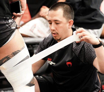 man taping an athlete's knee
