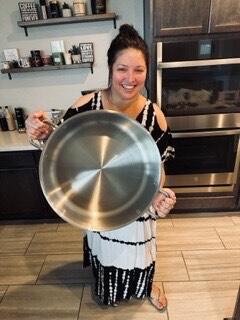 woman in kitchen holding large pot