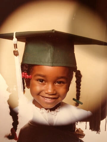 a vintage photo of a young girl in a graduation cap and gown