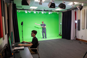 man standing in front of a green screen in studio