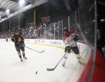 two hockey players pursuing puck