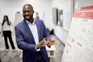 Gabson Baguma presenting a poster at an engineering symposium