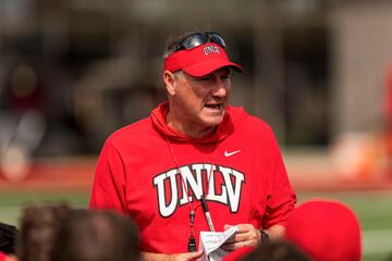 man in red UNLV sweatshirt coaching