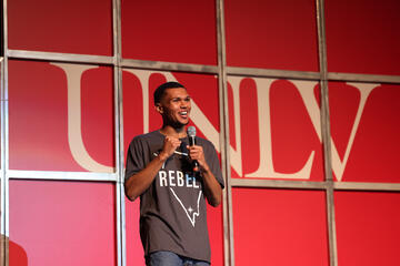 man with microphone speaking on stage