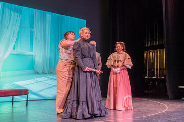 costume designer adjusts wardrobe for Hedda Gabler actress