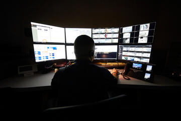man looking at several computer screens