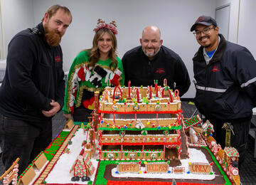 four people posing around gingerbread parking garage