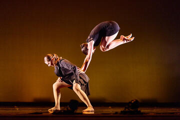 two acrobatic dancers performing an acrobatic routine