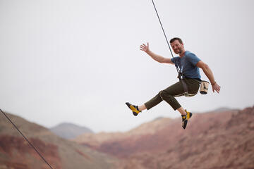 Tony Ferrar in mid air while rock climbing