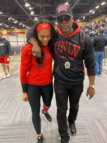 A woman and a man, both in UNLV athletic attire, walking together.