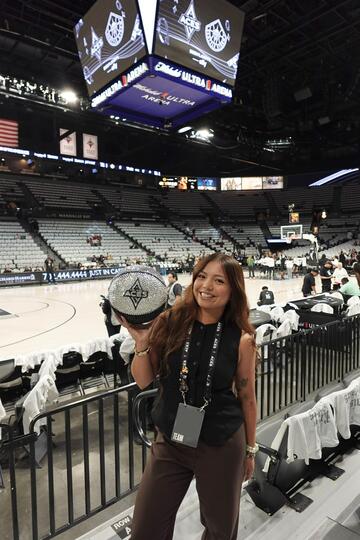 young female holding Aces basketball in basketball stadium