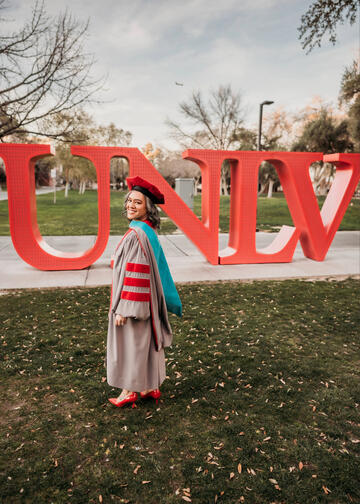 A portrait of Nancy Esposito in front of the UNLV red letters on the academic mall.